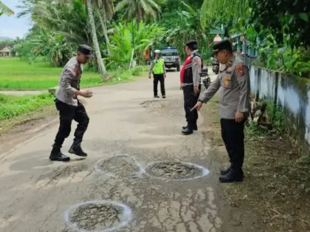 Polres Pacitan Tandai Jalan Berlubang Pakai Pilox Putih Jelang Mudik 2026 Foto BeritaJatim.com
