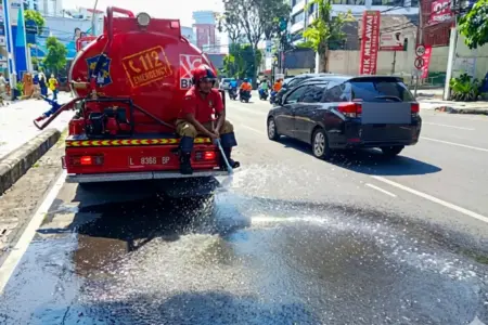 Antisipasi Heatstroke, Damkar Surabaya Siram Jalan Saat Suhu Panas Capai 30 Derajat Celsius Foto BeritaJatim.com