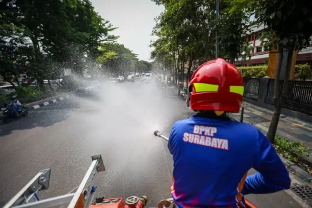 Lawan Suhu Menyengat dan Debu Proyek, Damkar Surabaya Turun Jalan Basahi Jalur Protokol Foto BeritaJatim.com